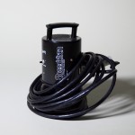 Photograph of Speedotron Light Head with cable wrapped around it and presented on a grey background.