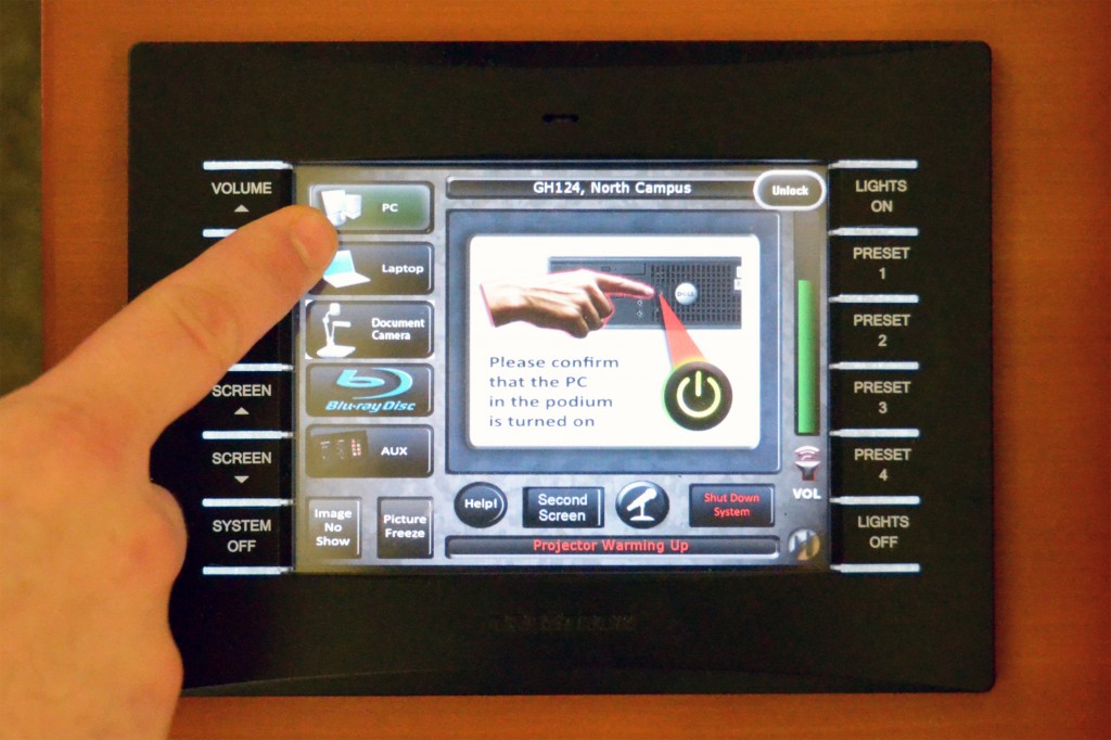 Photograph showing person selecting the PC input on podium touch panel.
