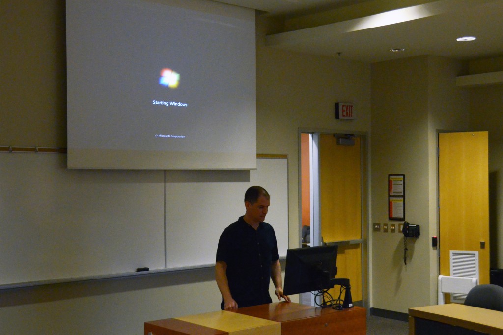 Photograph of a person standing in front of the classroom podium.