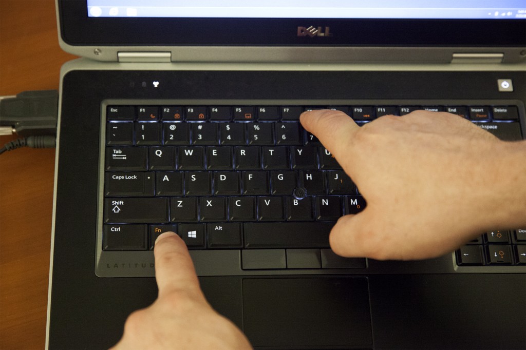 Closeup of a laptop keyboard with FN and F8 keys pressed